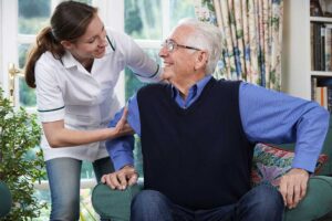 Older adults talking and smiling together at a dining table in a bright, welcoming communal space.